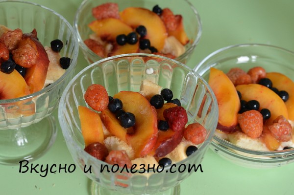 Поверх савоярди выкладываем дольки персика и свежие ягоды малины и черники